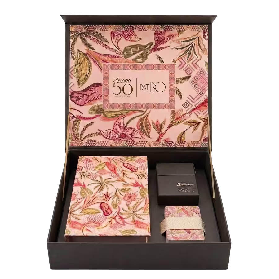 Zacapa x PatBO 50th Anniversary Collection gift set in an open black presentation box with pink tropical floral artwork, featuring a deck of cards, book box and matching scarf.