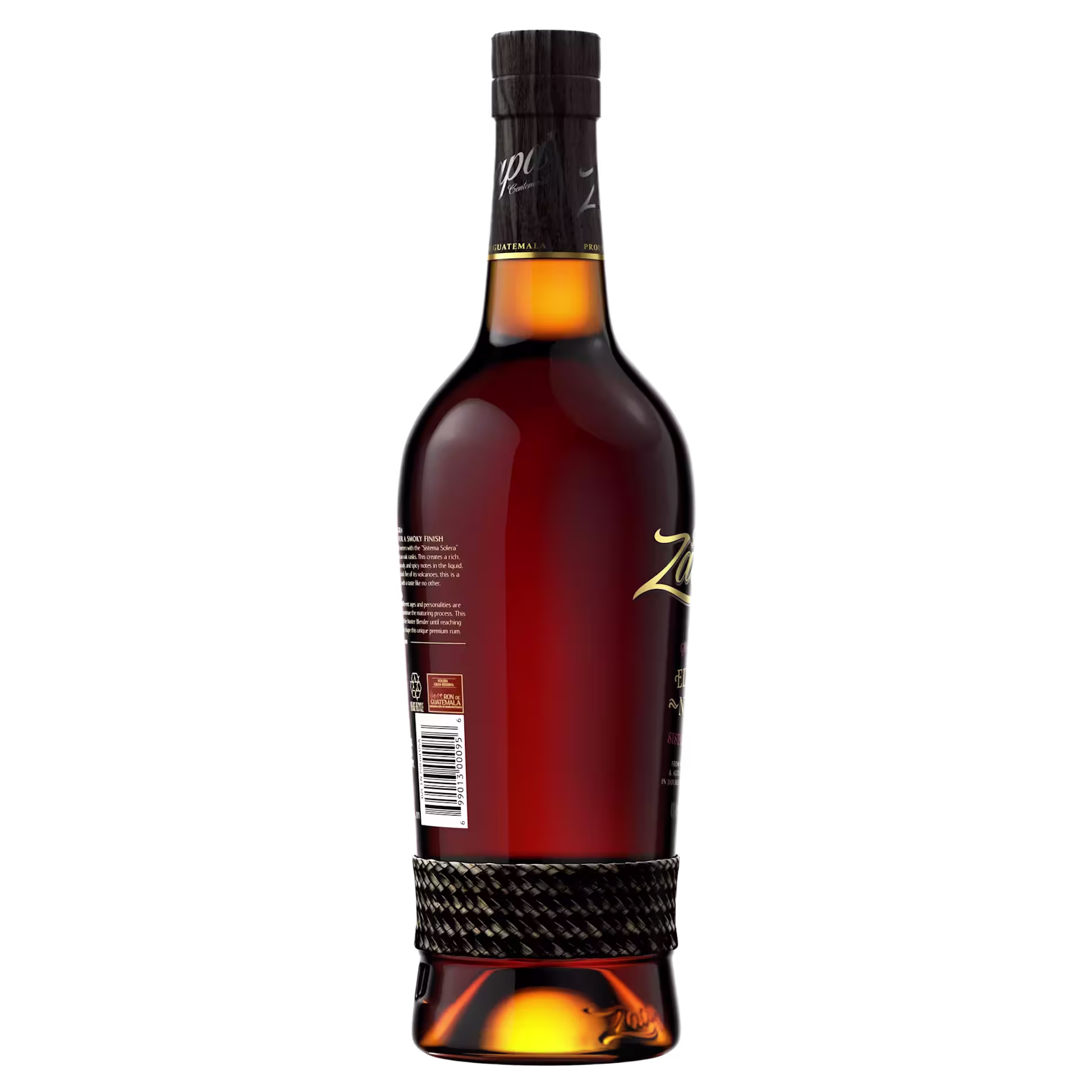 A dark glass bottle of liquor with a black and gold label, featuring a woven band around the lower part, shown against a black background.