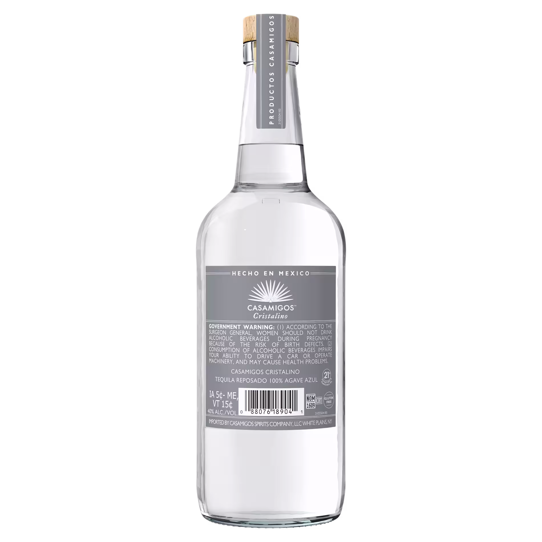 A clear glass bottle of Casamigos Cristalino tequila with a silver label and wooden cork, standing upright against a plain background.