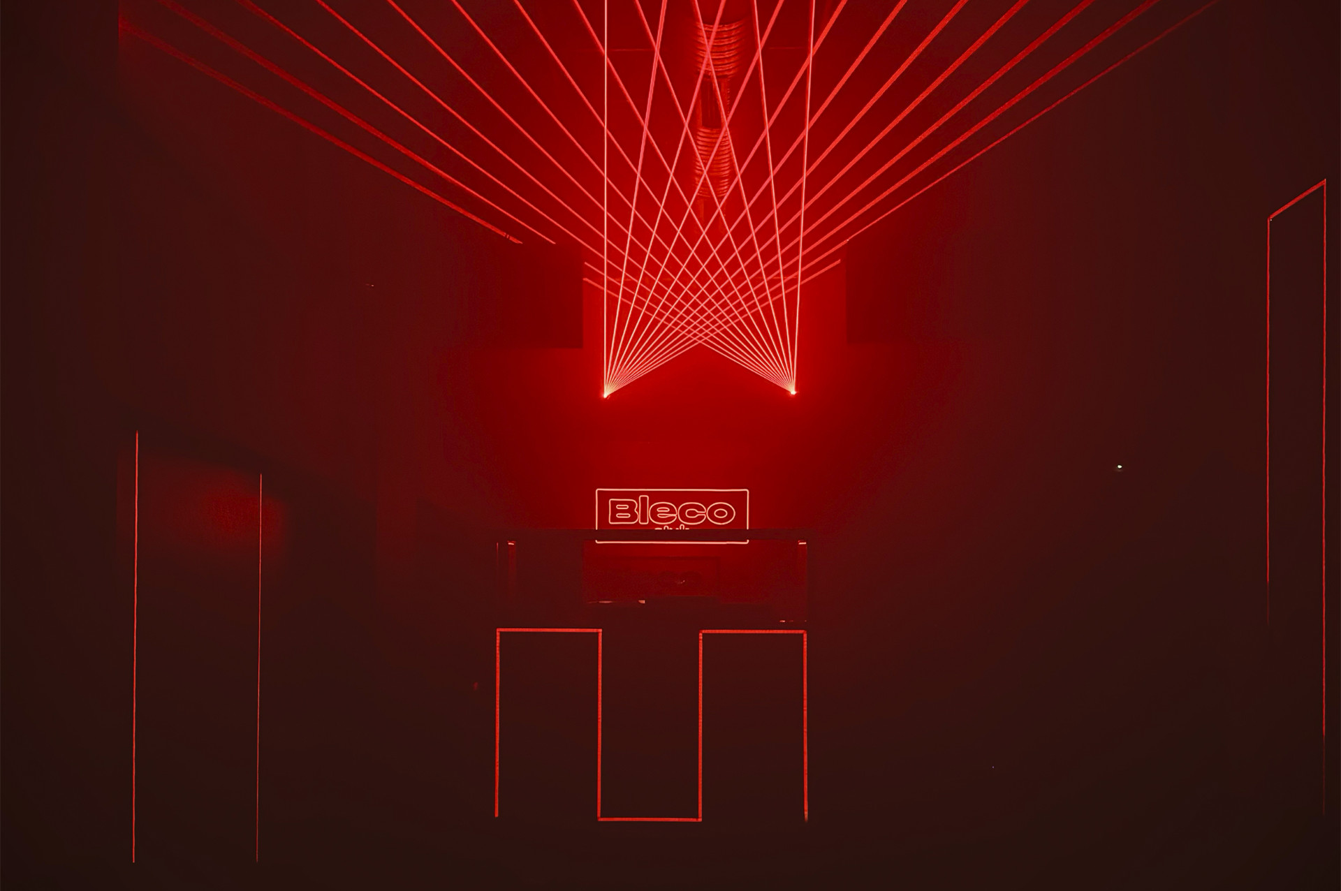 Escenario de Bleco Club con efectos de láser rojo y diseño minimalista que crea un ambiente moderno y futurista