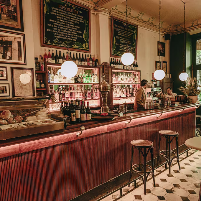 Cafè del Centre con barra clásica con encanto modernista, iluminación cálida y una cuidada selección de vinos y cócteles en un ambiente histórico.