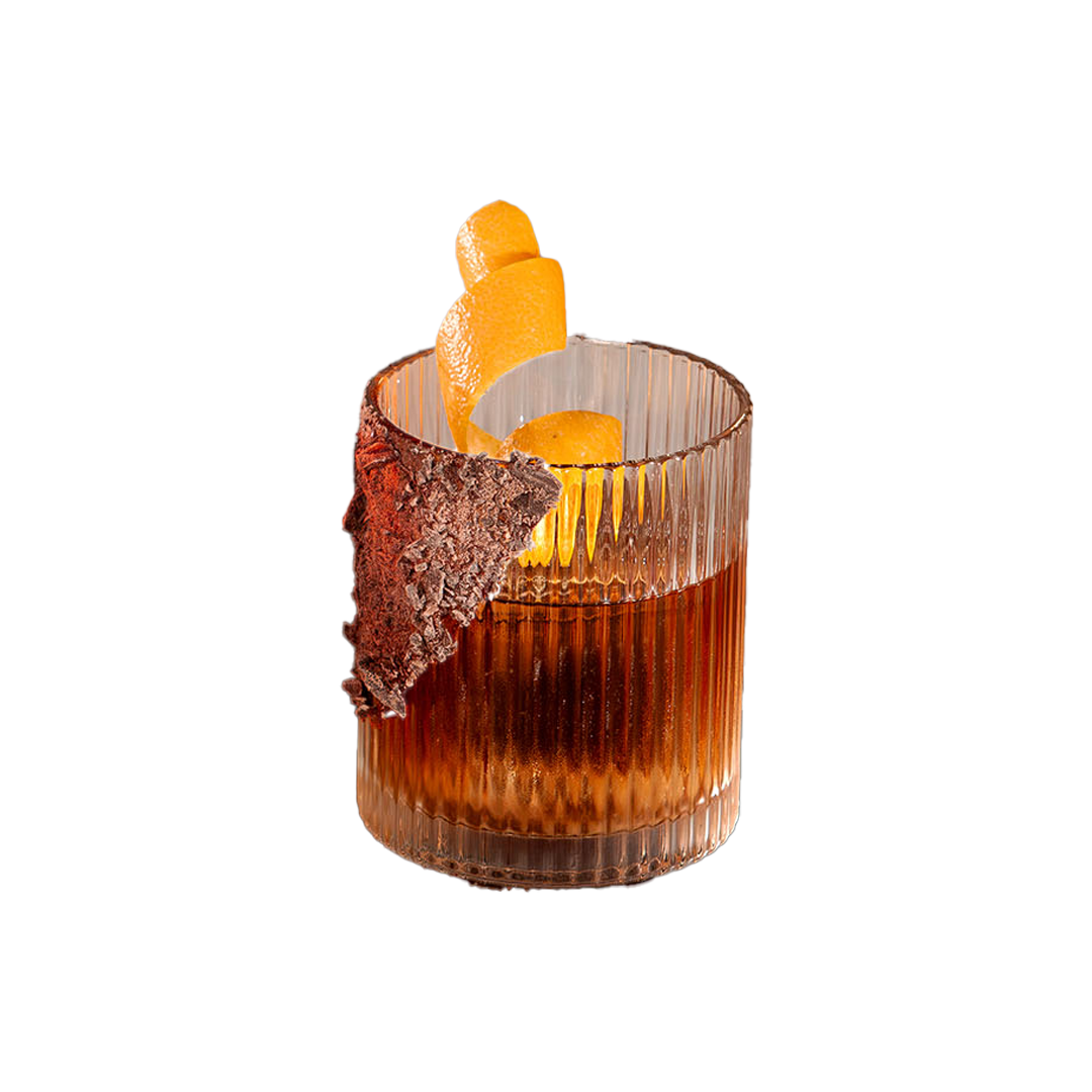 A cocktail in a ribbed glass with a textured rim garnish and an orange peel twist.