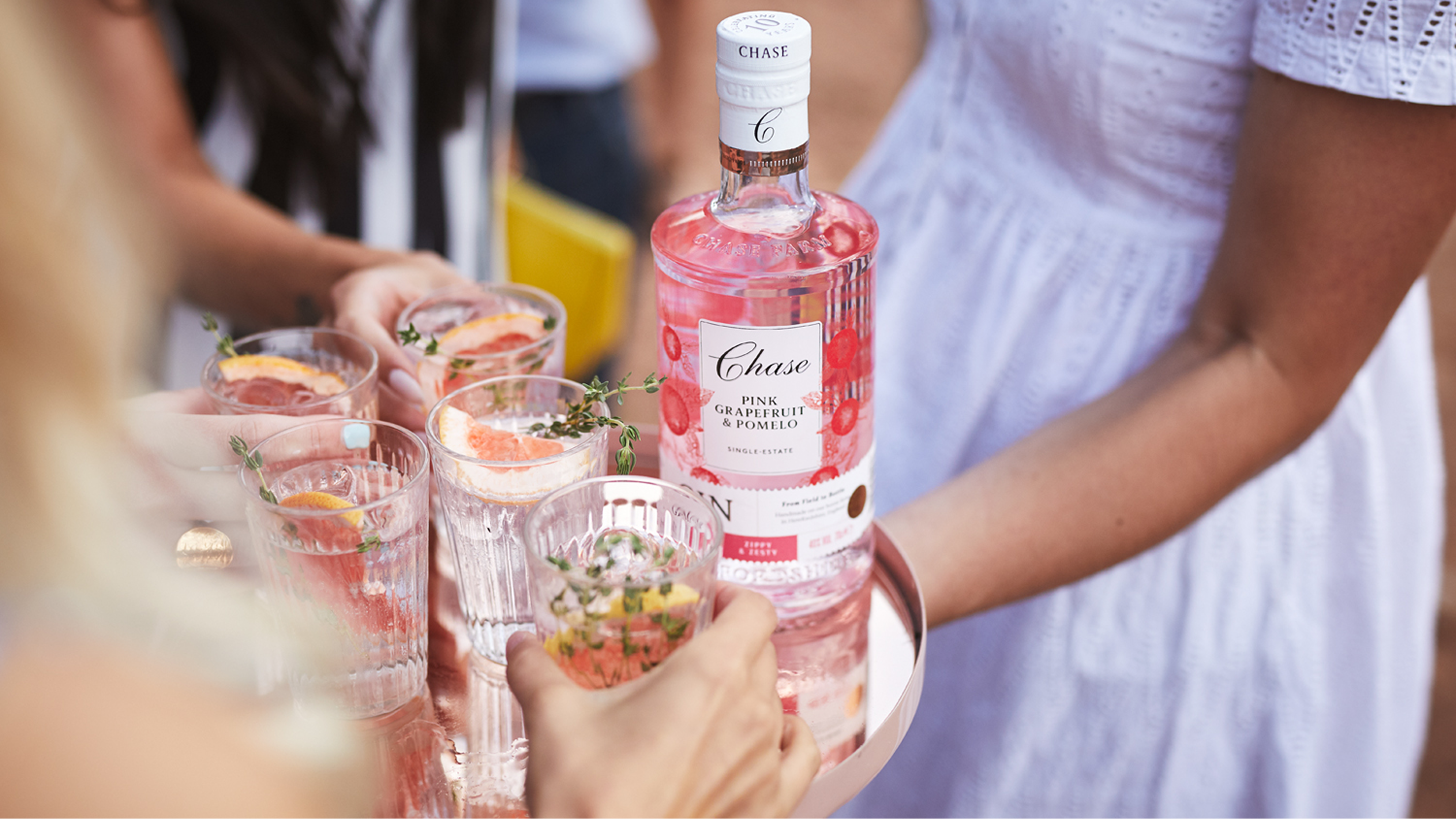 Host passing around tray with Chase Pink Grapefruit & Pomelo gin bottle and cocktails