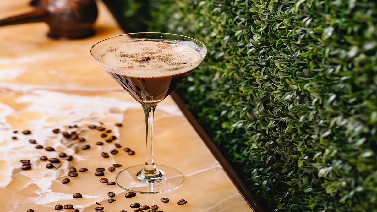 Un martini de ron y espresso con granos de café sobre la mesa