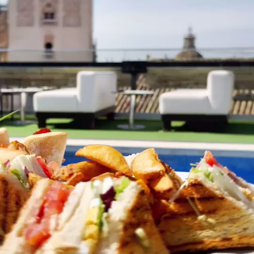 En Terraza Doña María, los bocados se disfrutan junto a la piscina con vistas únicas a la Giralda. Un rooftop que huele a verano en pleno corazón de Sevilla.