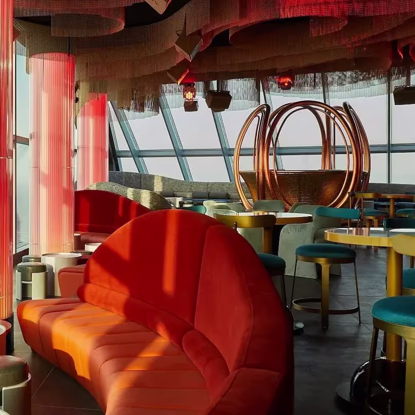 Atardecer en Noxe - W Hotel, con vistas al mar, diseño moderno y sofás cálidos que invitan a disfrutar de una experiencia única.