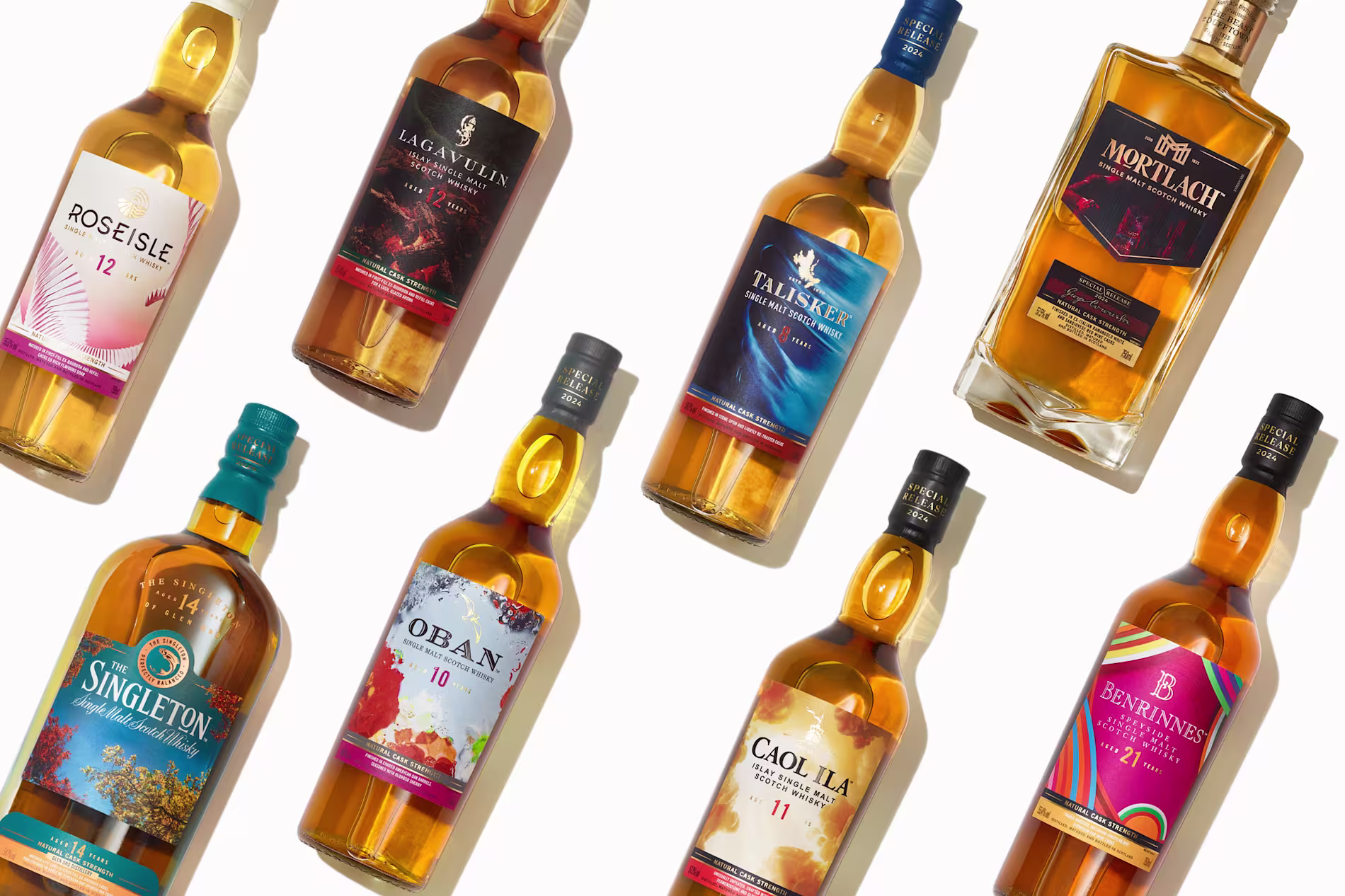 Eight assorted bottles of Scotch whisky are arranged diagonally on a white background, each with distinct labels and colors.