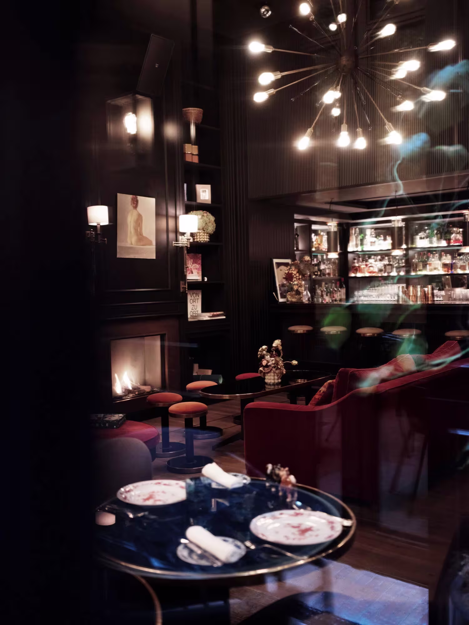 Interior de Contraban, con ambiente íntimo, chimenea, iluminación cálida y decoración sofisticada para una experiencia acogedora.