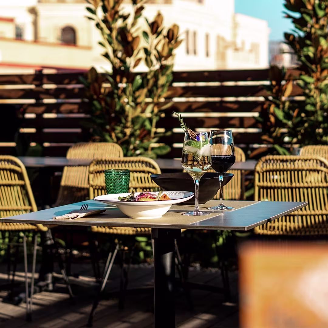 Mesa exterior en Keyzen, ideal para disfrutar de una comida al aire libre con vistas y un toque de sofisticación.