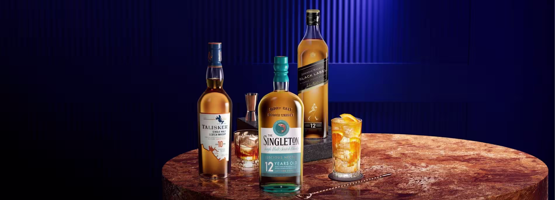 The Singleton, Talisker and Johnnie Walker whisky bottles on marble table