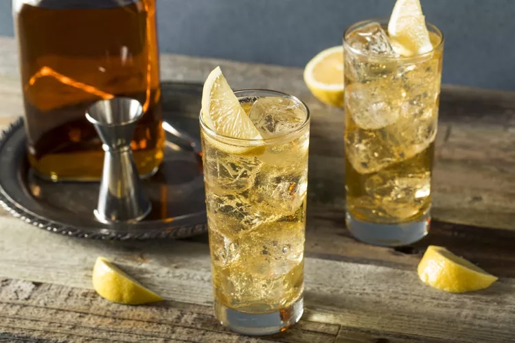 2 glasses of Whisky Highball on a brown table with slices of lemons in