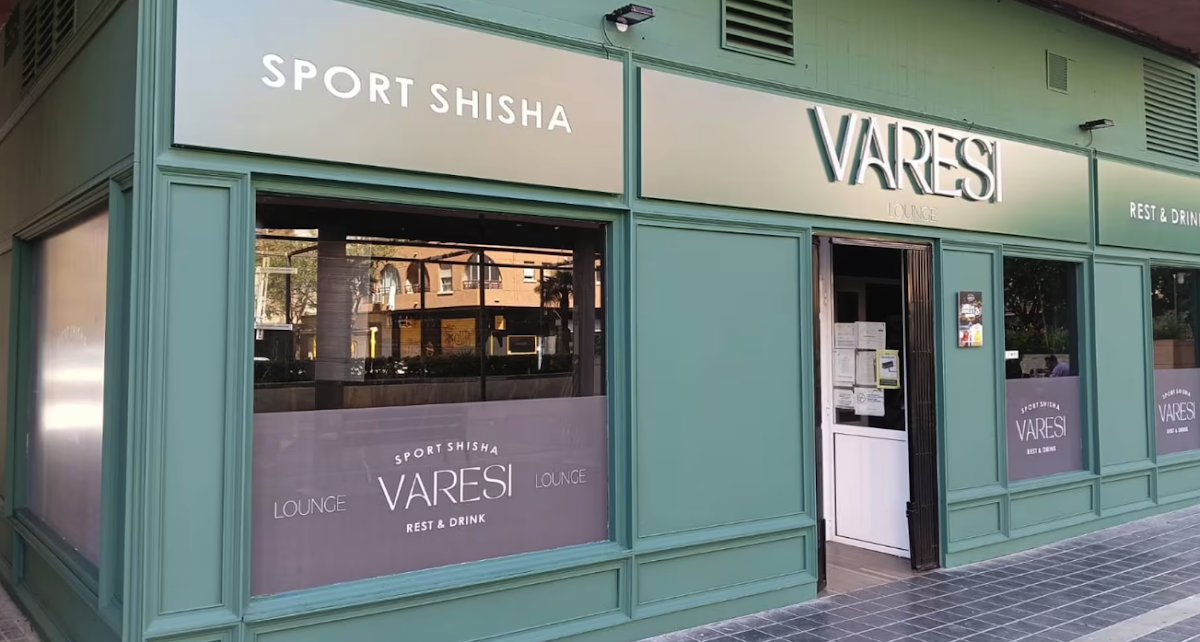 Fachada verde de Varesi Lounge con rótulos que anuncian shisha, deporte y cócteles, ventanales amplios y entrada principal abierta al público.