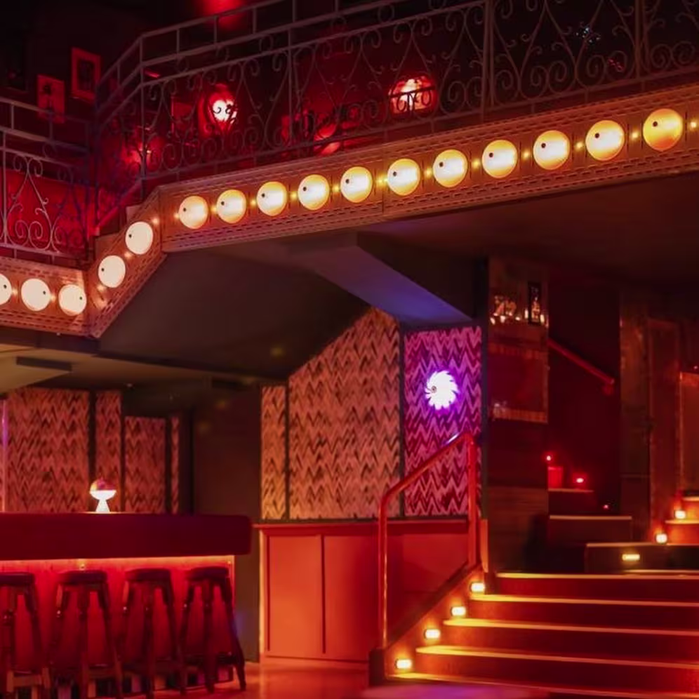 Salvaora Brown: Un espacio con una atmósfera íntima y sofisticada, iluminado suavemente para crear un ambiente acogedor. La decoración incluye detalles vintage y un elegante juego de luces que resalta su diseño retro y moderno a la vez.