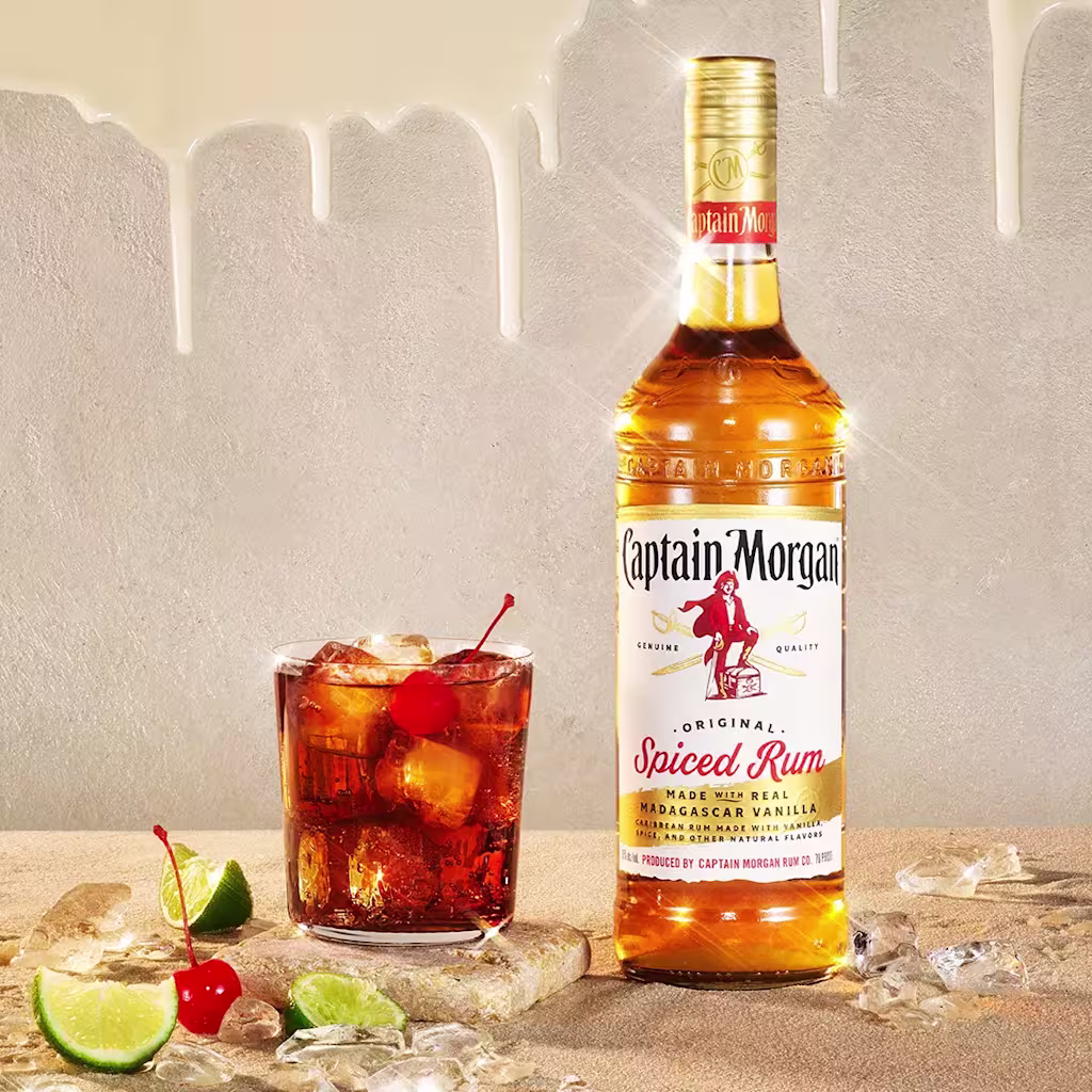 Captain Morgan Original Spiced bottle on table with cocktail