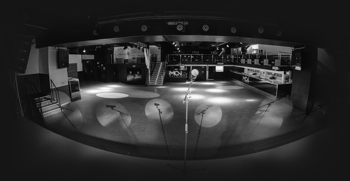 Sala Mon vacía antes del show, con luces listas y un micrófono esperando a encender la noche.