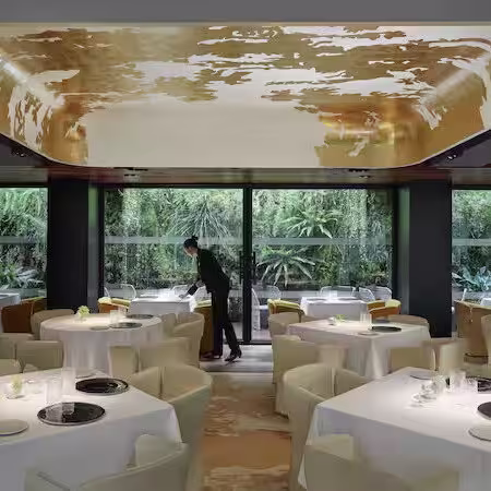 Recepción del Mandarin Oriental Barcelona, con un diseño moderno y elegante, destacando tonos cálidos, iluminación sofisticada.