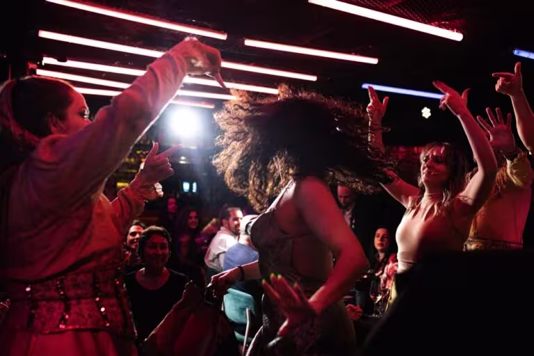 Energía vibrante en Bule Bule con personas bailando bajo luces de neón, celebrando la música y el ambiente festivo del lugar.