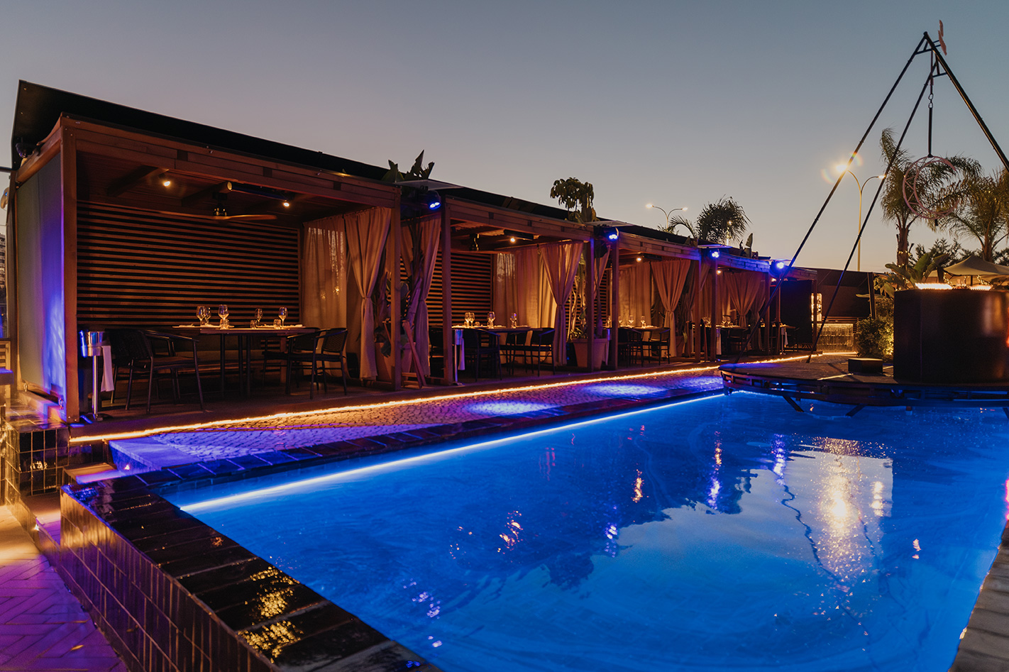 Piscina iluminada y cenas privadas al aire libre en Maquiavelo, una escapada nocturna llena de elegancia y magia.