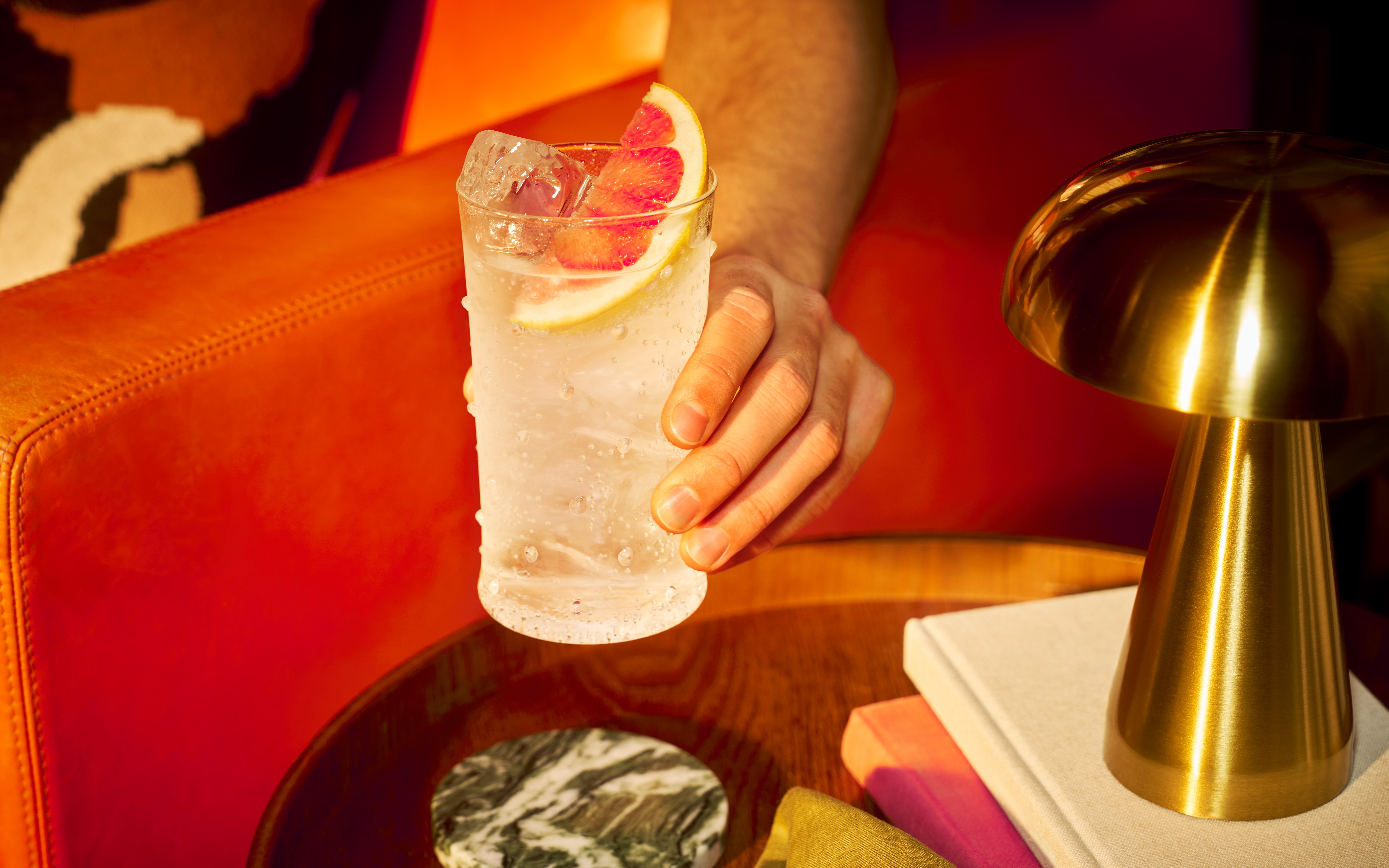 A tall cocktail garnished with a slice of grapefruit