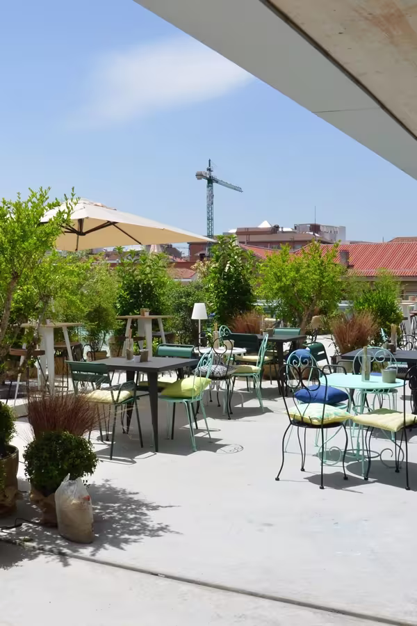 Azotea Forus presenta un espacio al aire libre decorado con sillas coloridas, mesas elegantes y vegetación, ideal para disfrutar del buen tiempo.