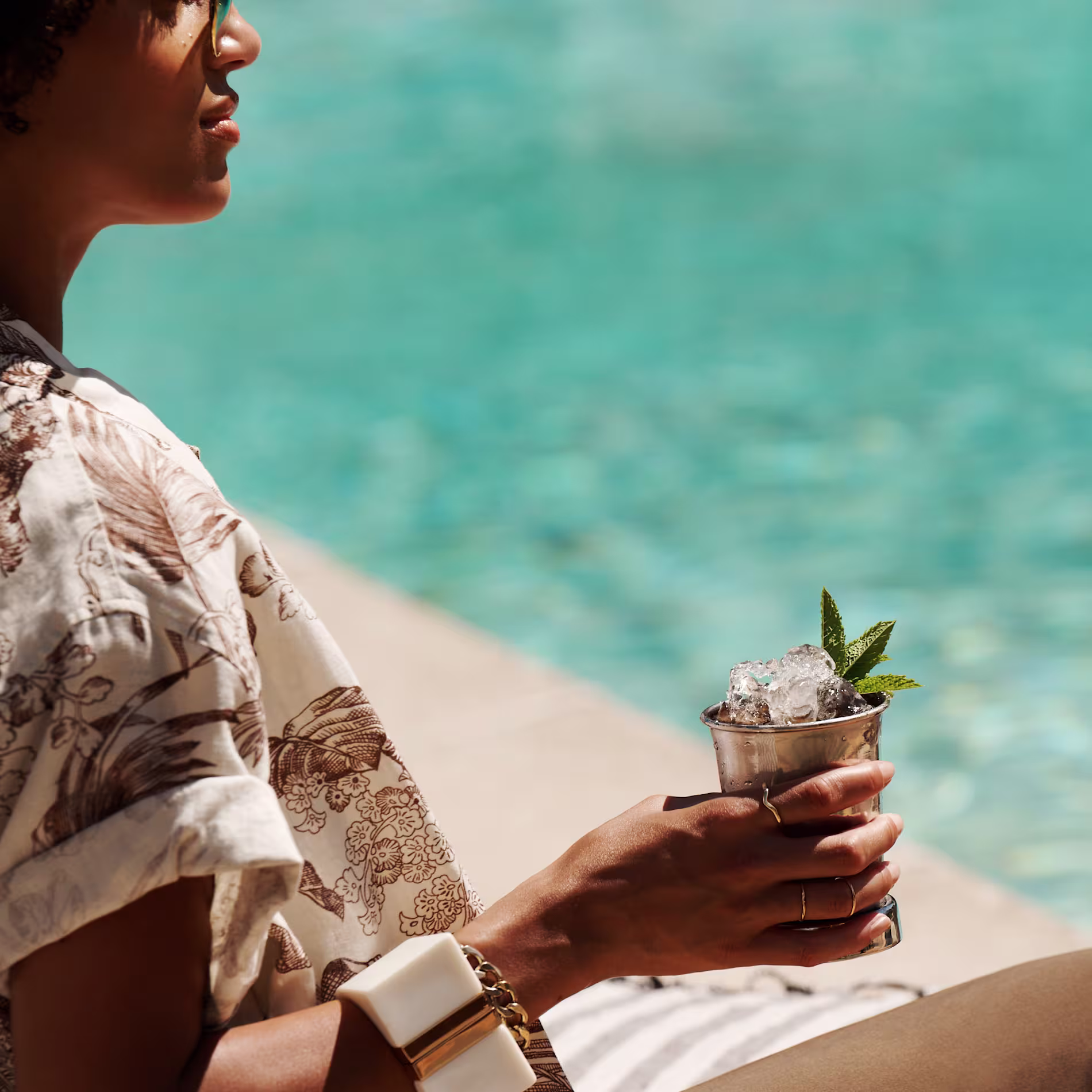 A woman holds a Kentucky Mule cocktail by a swimming pool
