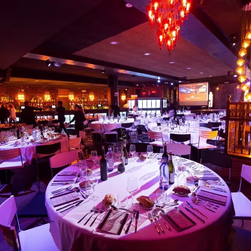 Indara, un elegante salón para eventos, mesas impecablemente vestidas, candelabros vibrantes y un ambiente cálido y sofisticado.