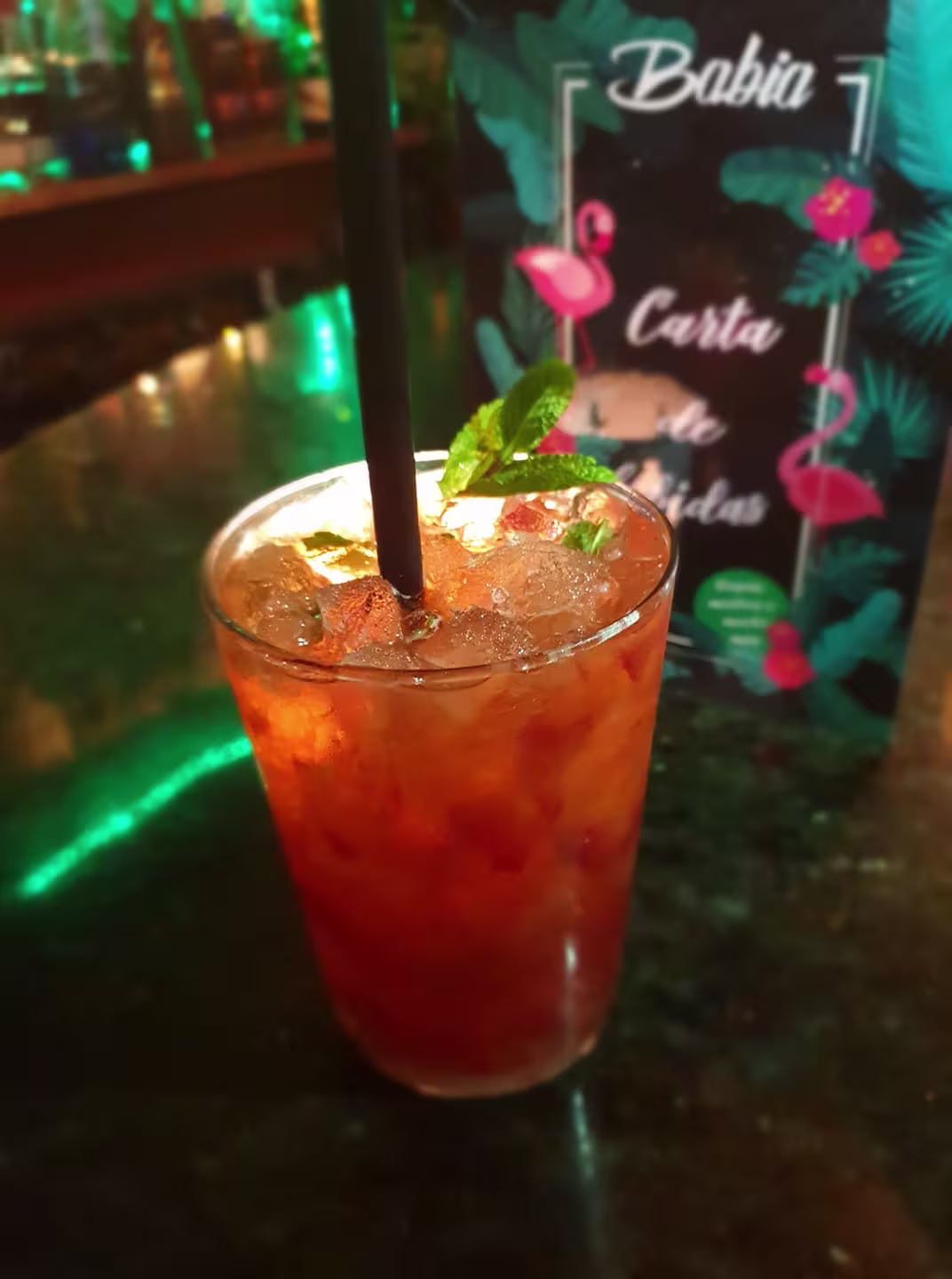 Cóctel refrescante servido en Babia, con menta fresca y hielo picado, acompañado de una carta de bebidas tropical.