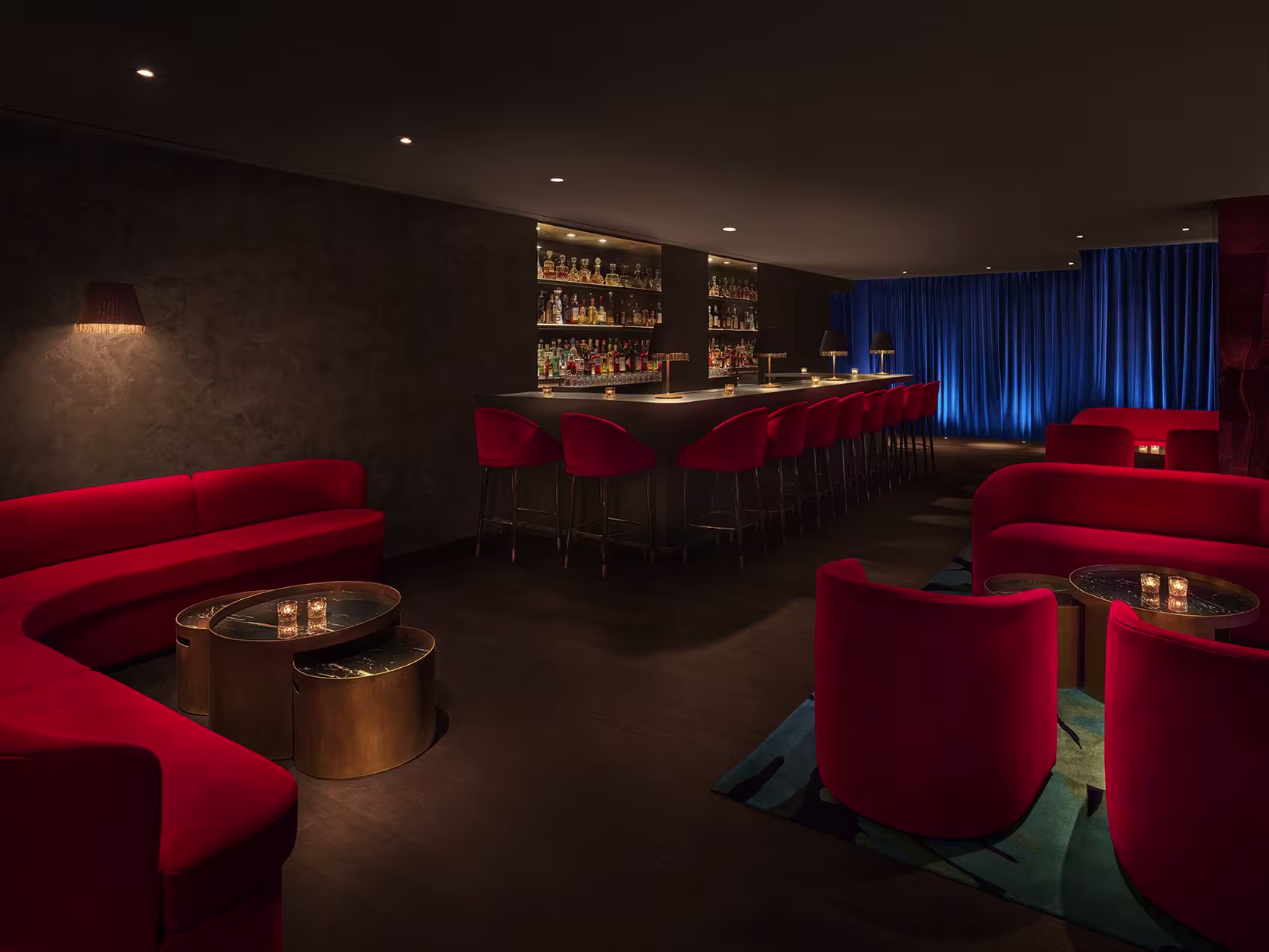 Mística ofrece un ambiente elegante y sofisticado con su iluminación tenue y muebles de terciopelo rojo, creando una atmósfera íntima perfecta.