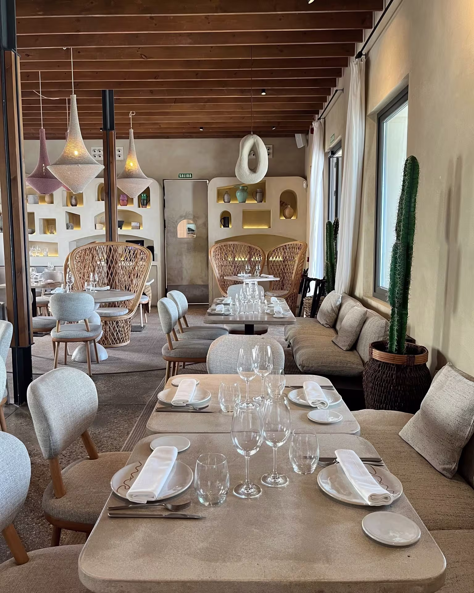 Interior de El Cuartel del Mar, con mesas elegantemente dispuestas, tonos cálidos y una decoración acogedora de inspiración mediterránea.