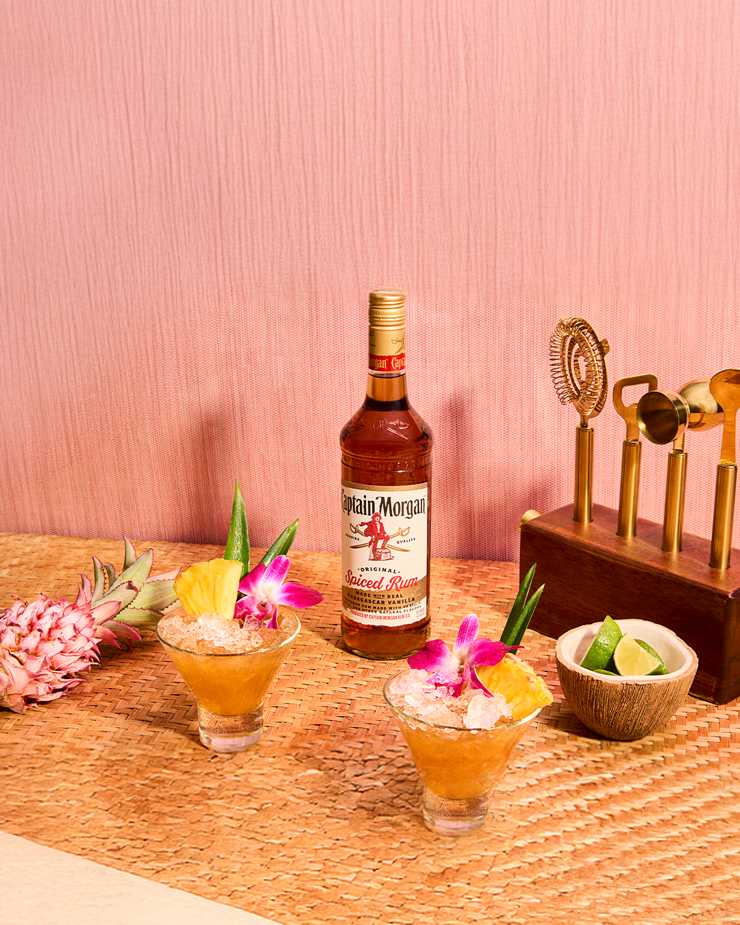Captain Morgan Spiced Rum bottle with cocktail utensils and glasses