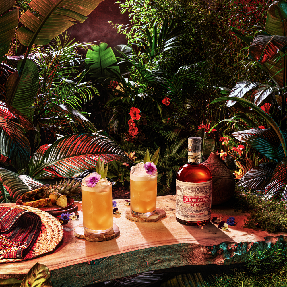 Don Papa Rum bottle with 2 glasses of Birds of a Feather cocktails