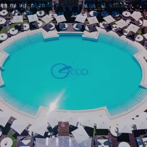 Vista cenital de la piscina de Occo, rodeada de sombrillas blancas, camas balinesas y puro ambiente exclusivo en Sevilla.