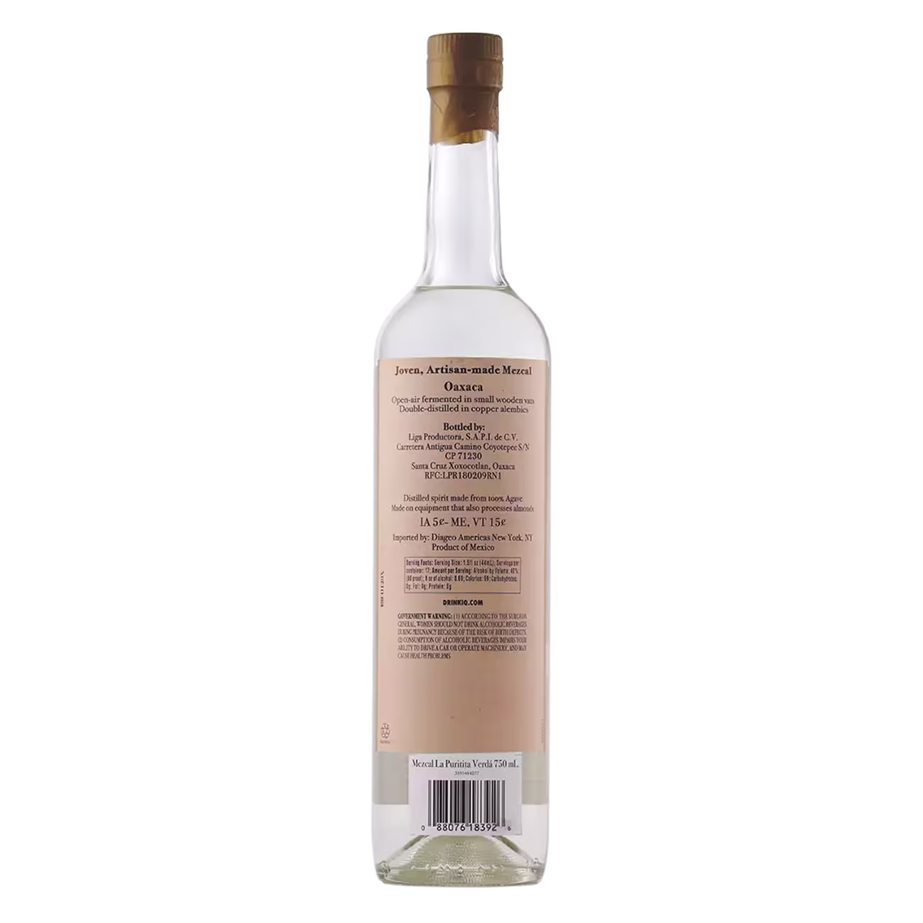 A clear glass bottle of mezcal shown from the back, featuring a tan label with detailed product information and a wooden cork stopper.