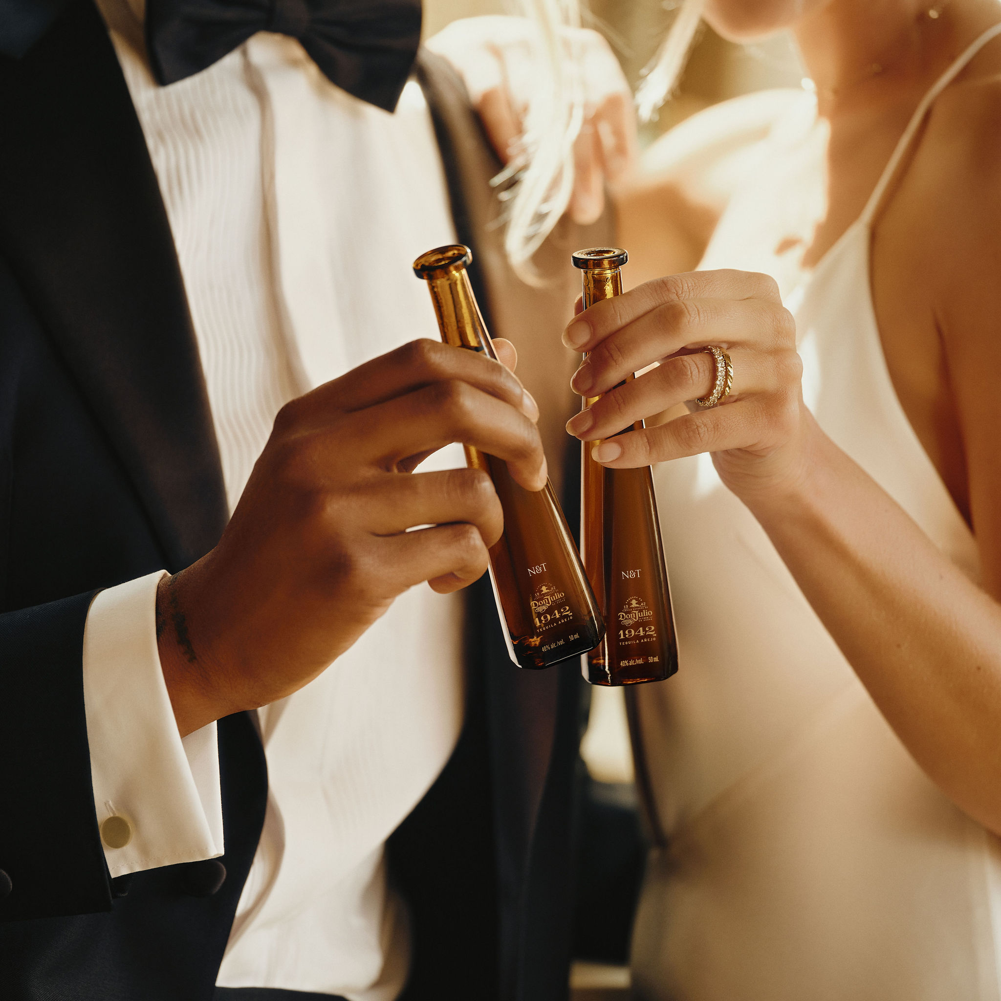 Newly married couple toasting with personalised bottles of Don Julio 1942.