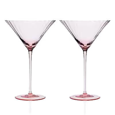 Two empty, clear martini glasses with a slight pink tint are standing side by side on a white background.