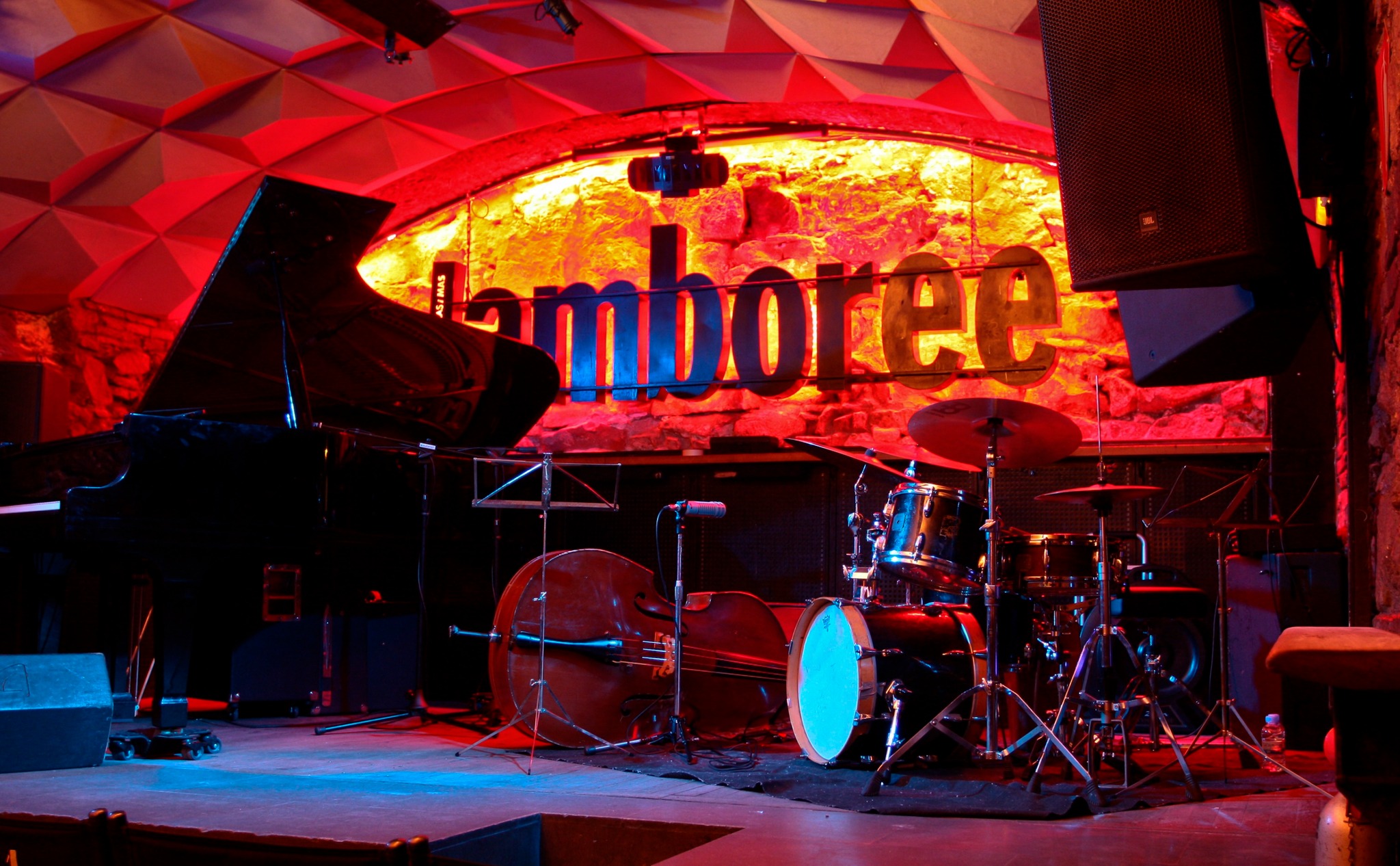 Jamboree es un icónico club de jazz con iluminación cálida, batería, contrabajo y piano, ideal para noches de música en vivo y buen ambiente.