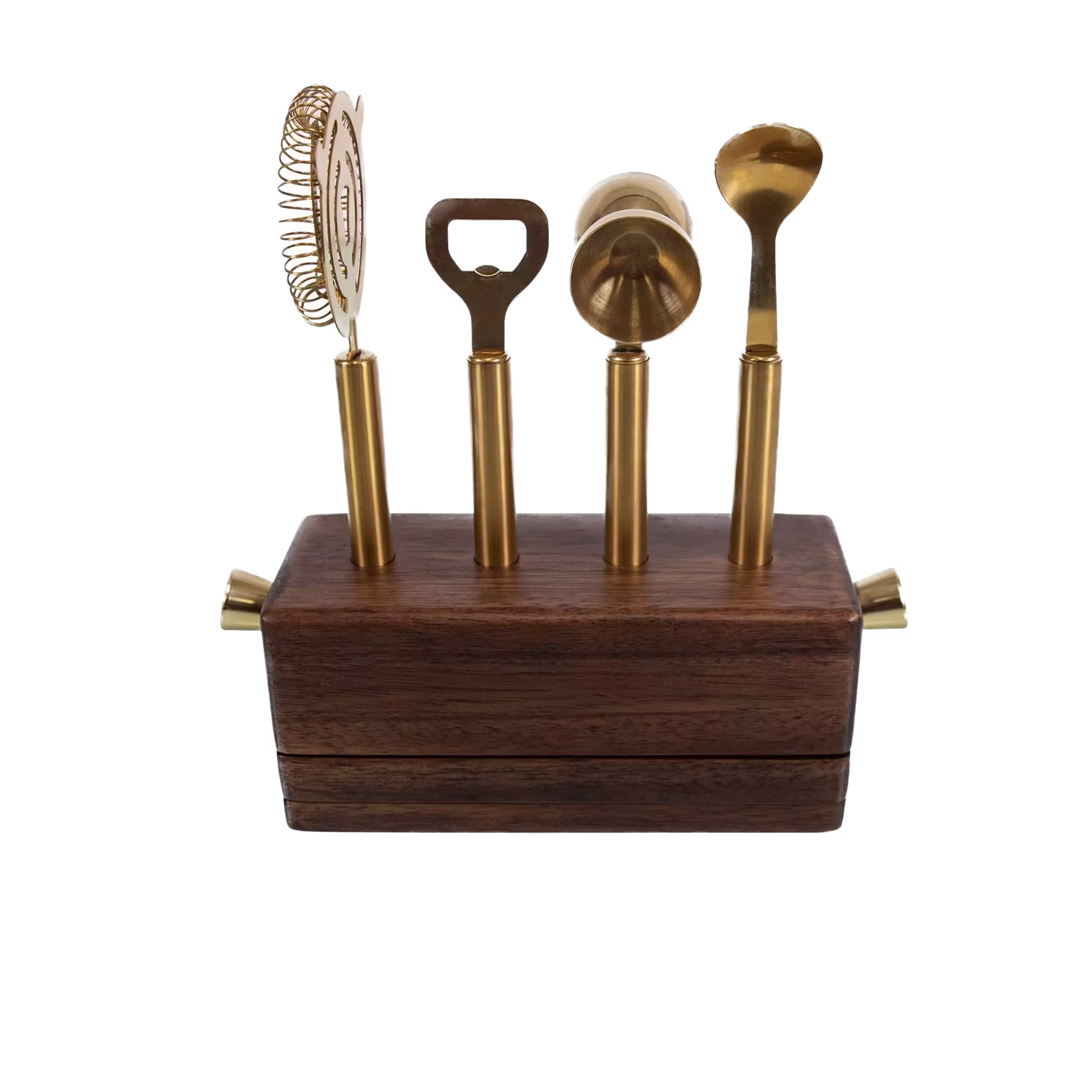 A wooden block holds four gold bar tools: a strainer, bottle opener, jigger, and spoon, each standing upright in its own slot.