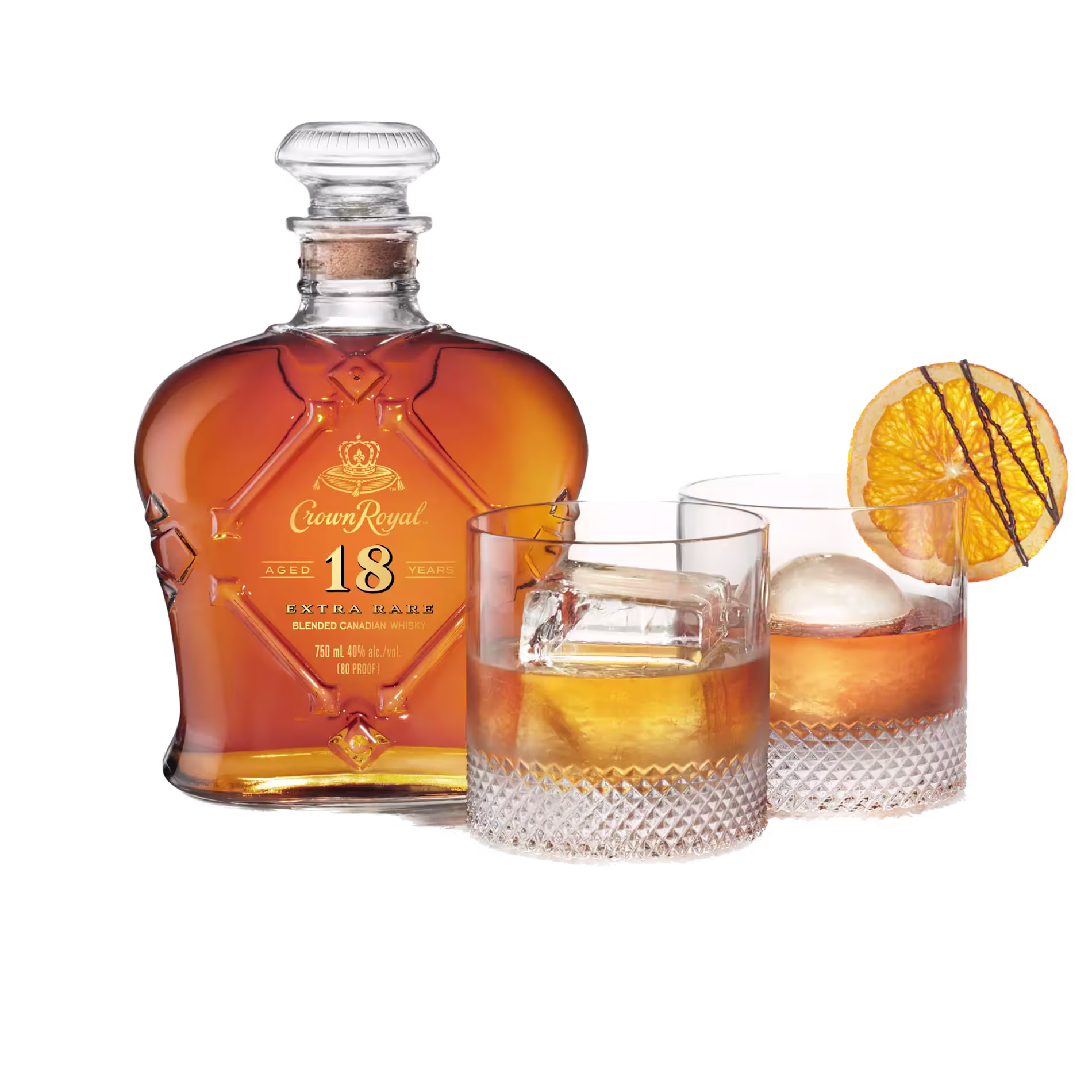 A bottle of Crown Royal 18 Year Old whiskey next to two glasses filled with whiskey, ice, and an orange slice garnish.