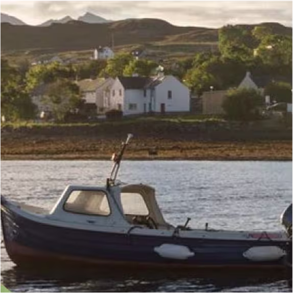 Small boat on coastal water near a Scotch whisky distillery, representing regional origins