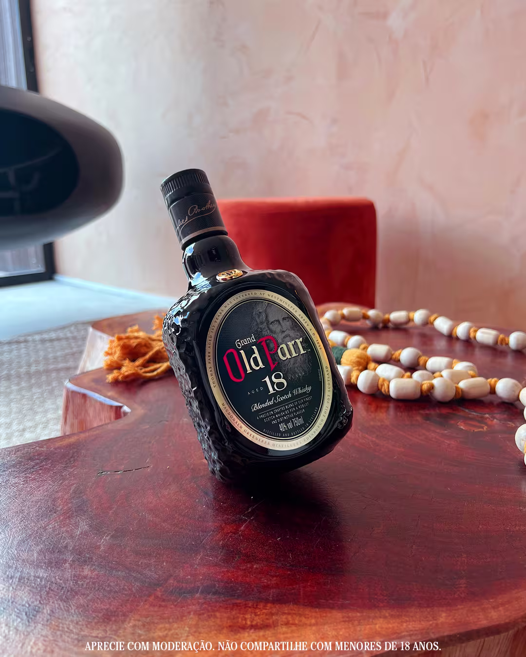 Old Parr Aged 18 Years Blended Scotch Whisky bottle showcase on desk under lamp spotlight