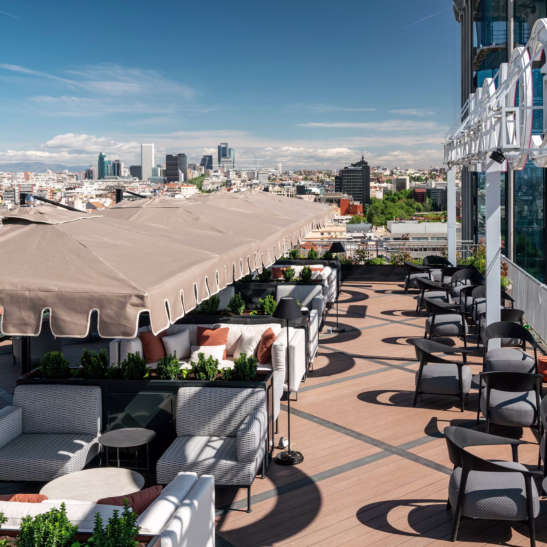 The Bar | Club Financiero Génova - Espacio exterior en la terraza del Club Financiero Génova, mostrando la zona de asientos con vistas al skyline de Madrid.