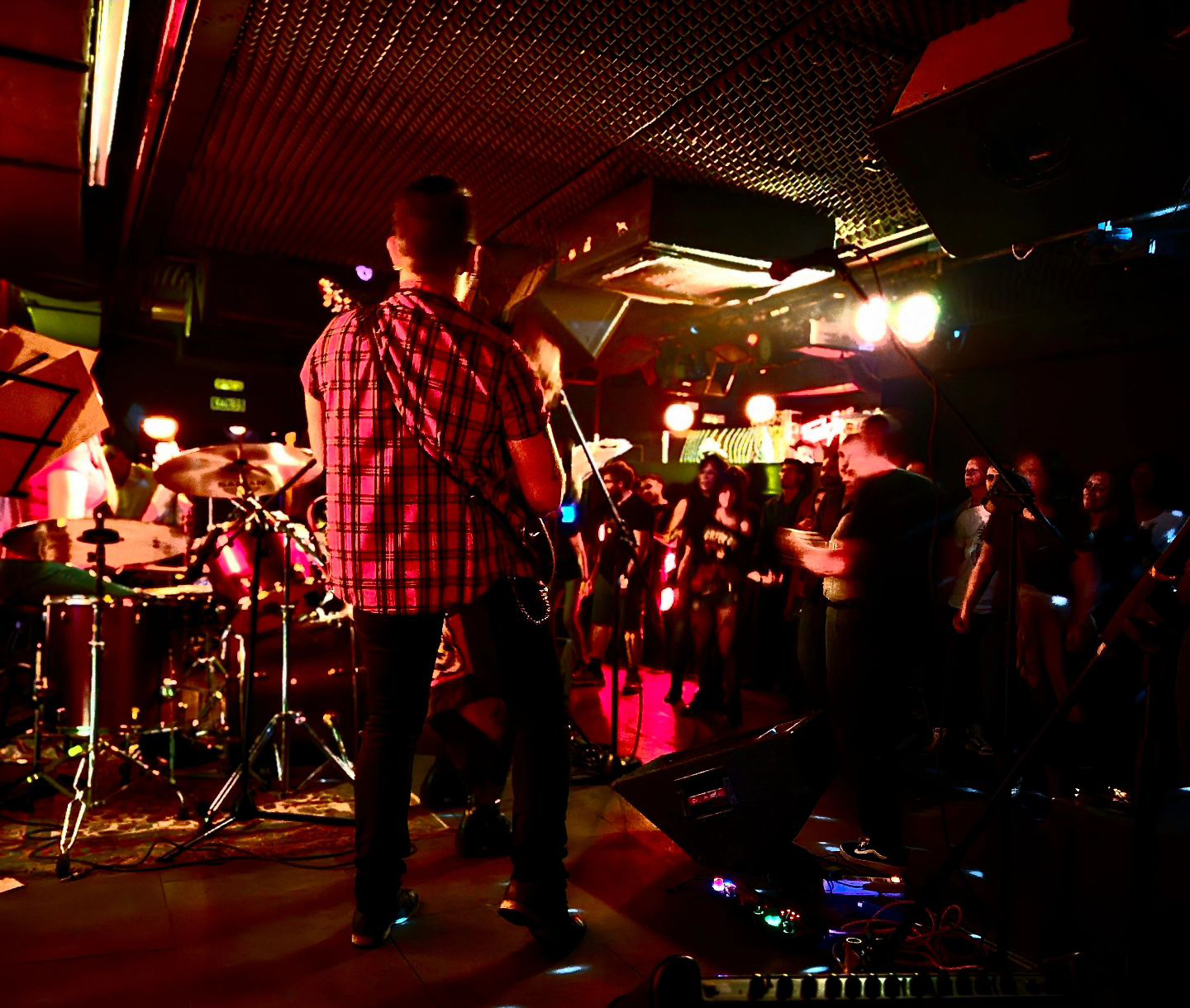 La imagen muestra una presentación en vivo en la Sala Maravillas, donde una banda toca ante un público cercano y entusiasta. Con iluminación tenue y un ambiente íntimo, el lugar ofrece una experiencia cercana y auténtica.