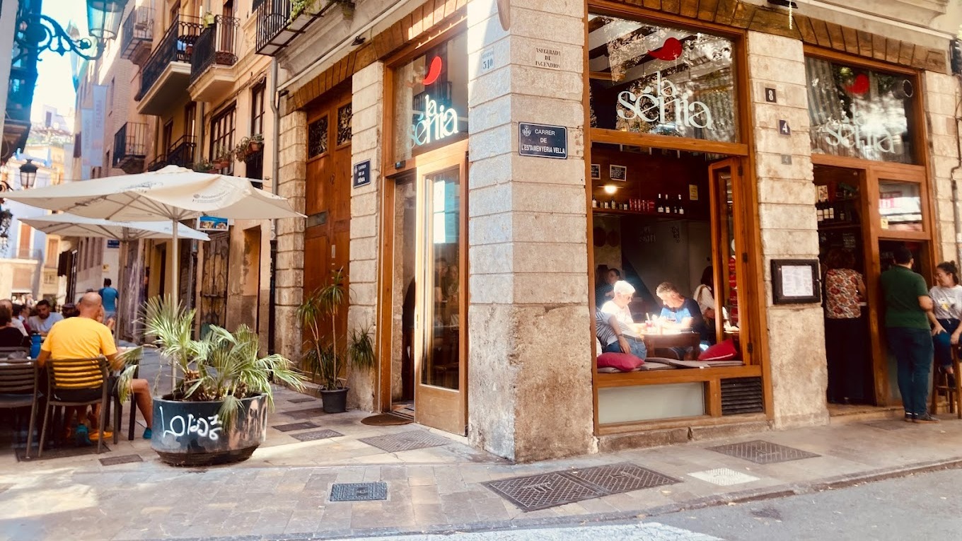 Esquina encantadora en el casco antiguo con terraza soleada y ambiente animado en La Sénia, ideal para tapear y disfrutar del ritmo de la ciudad.
