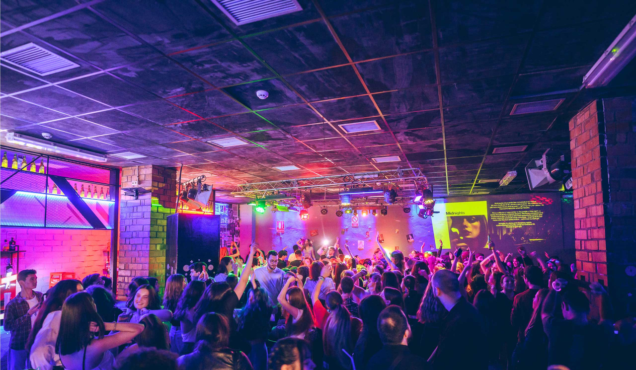 La pista de baile de Plataforma, llena de energía y luces coloridas, crea un ambiente vibrante para disfrutar de música y diversión con un público entusiasta.