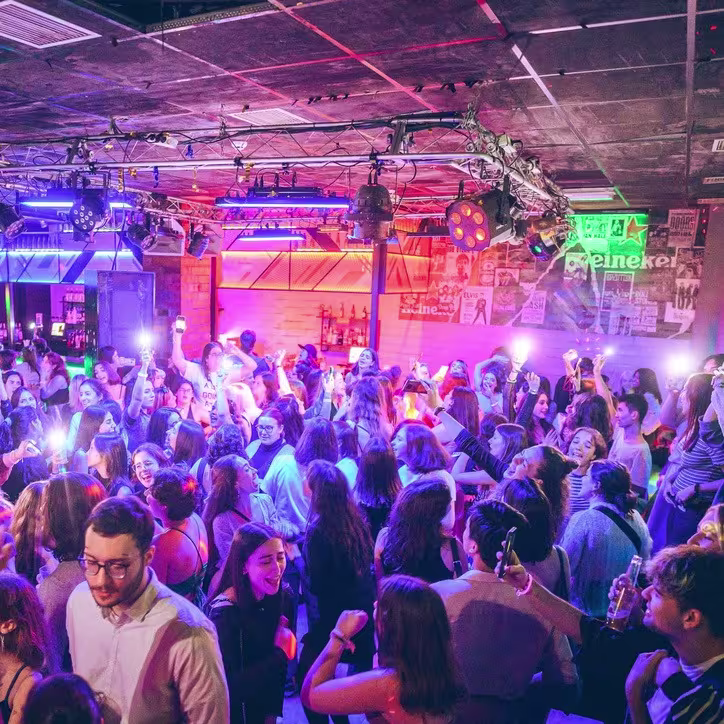 Multitud bailando bajo luces de colores en la discoteca Plataforma.