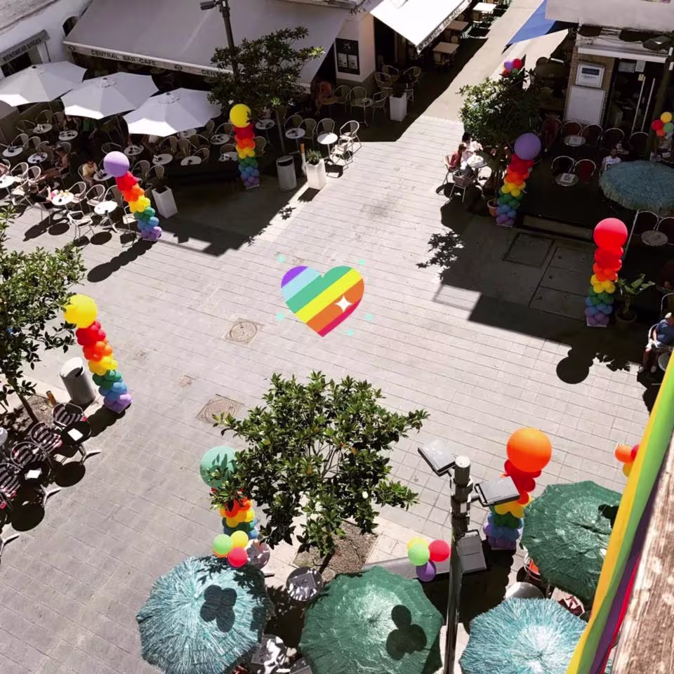 Celebración al aire libre en Parrots, decorada con colores del orgullo, creando un ambiente vibrante y acogedor.