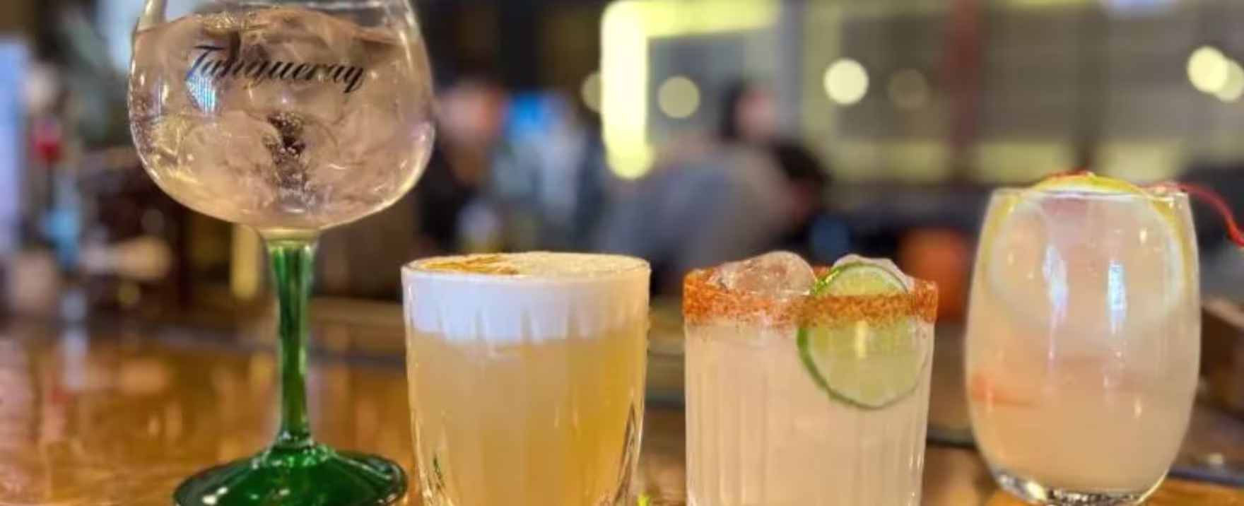 La imagen muestra cuatro cócteles servidos en distintos tipos de copas y vasos.