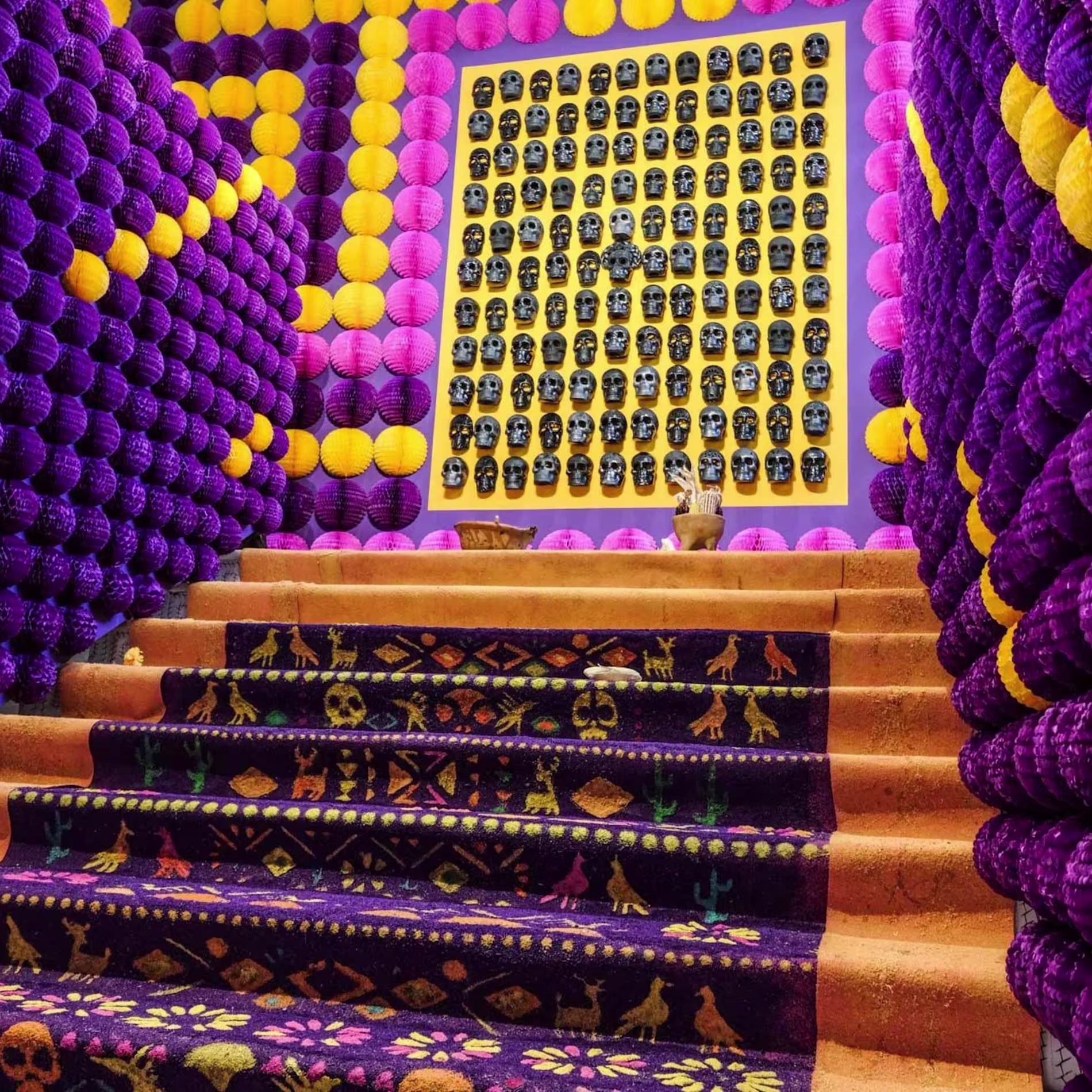 Escalera colorida con pasamanos de pelotas y calaveras.