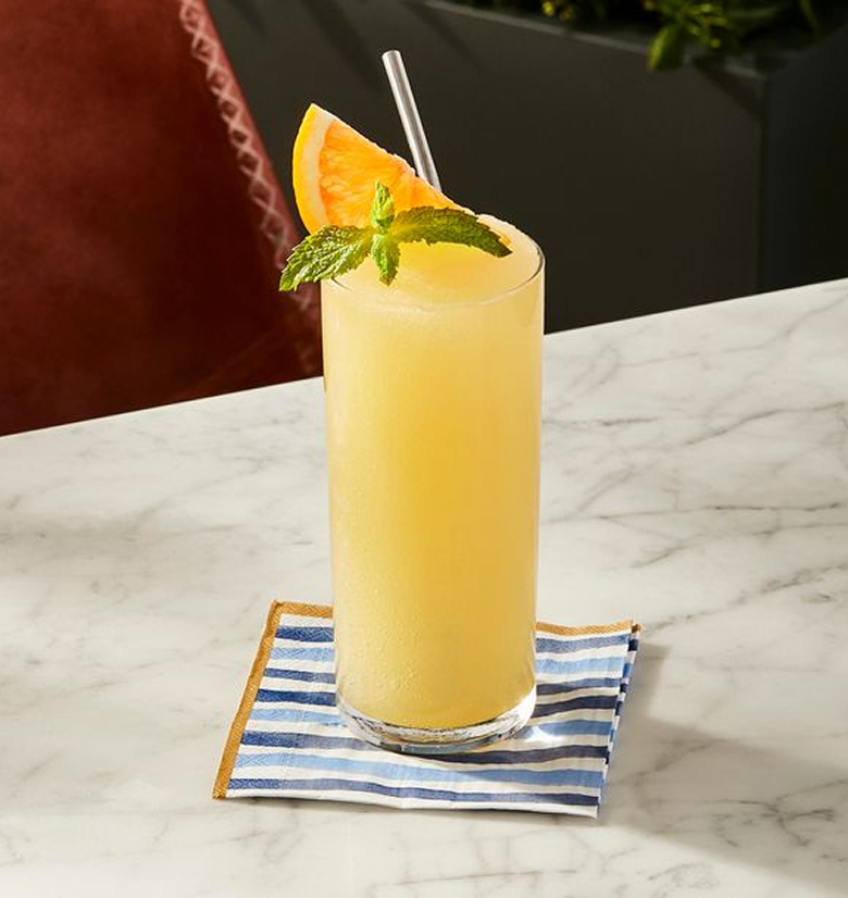 Johnnie Walker Red Label & Orange cocktail garnished with orange sitting on a blue and white striped napkin