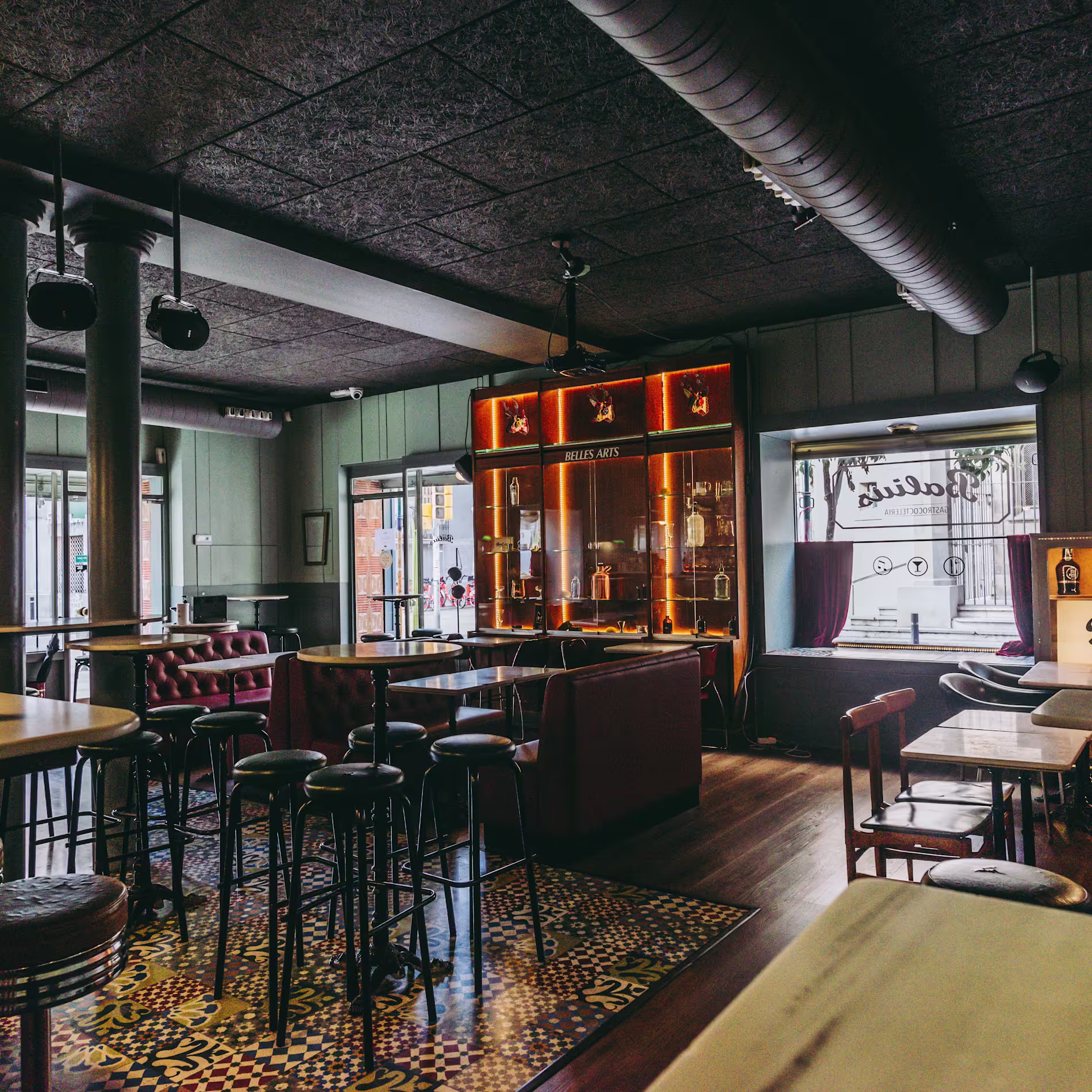 Balius Bar deslumbra con su vitrina iluminada llena de arte mixológico y un ambiente que mezcla elegancia retro y modernidad.